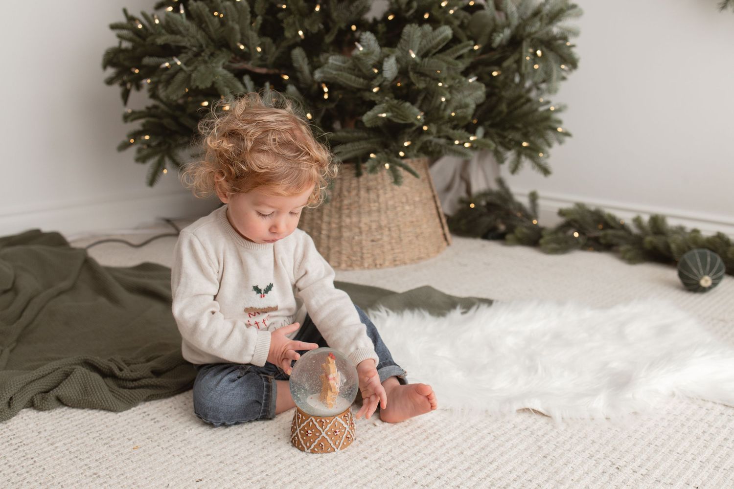 Cozy Christmas scene with a decorated tree, white carpet, and woven basket in soft lighting. Photography in Buckinghamshire.