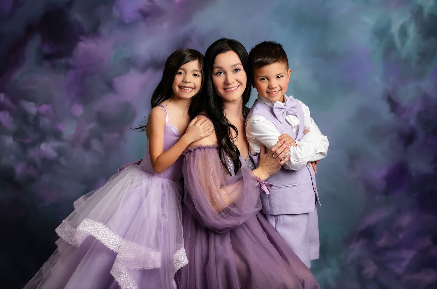 A family wearing coordinated purple and white outfits poses together in a series of outdoor portraits.