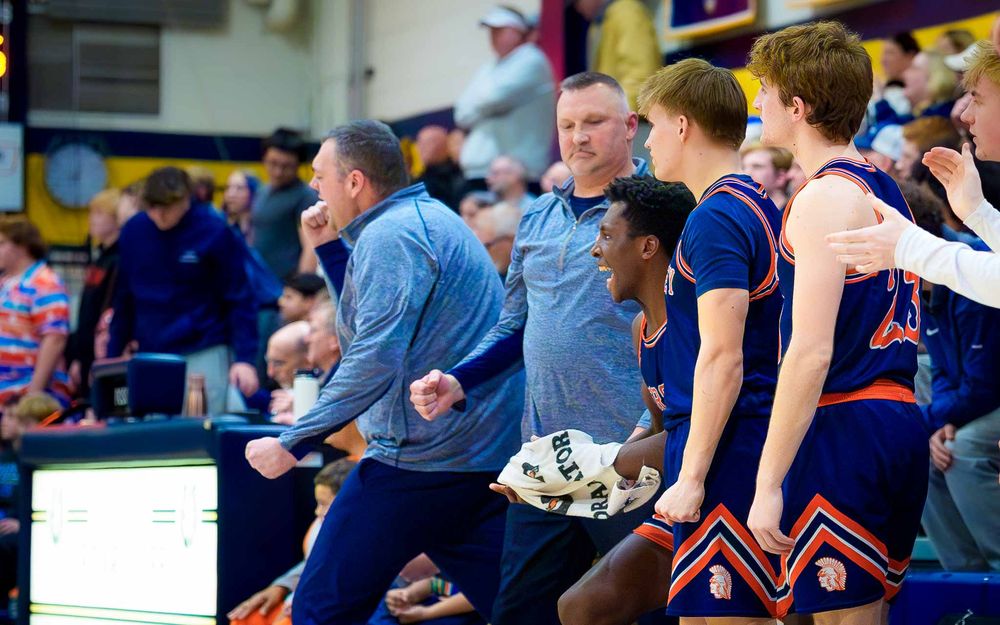 Hershey Trojans coaches and players erupt in celebration on the sidelines after a big play by SportsFox Photography, Hershey PA.