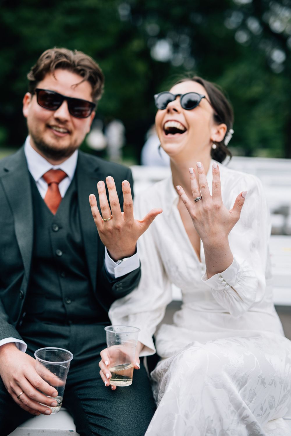 Candid wedding photo series showing couple laughing and enjoying drinks together outdoors.