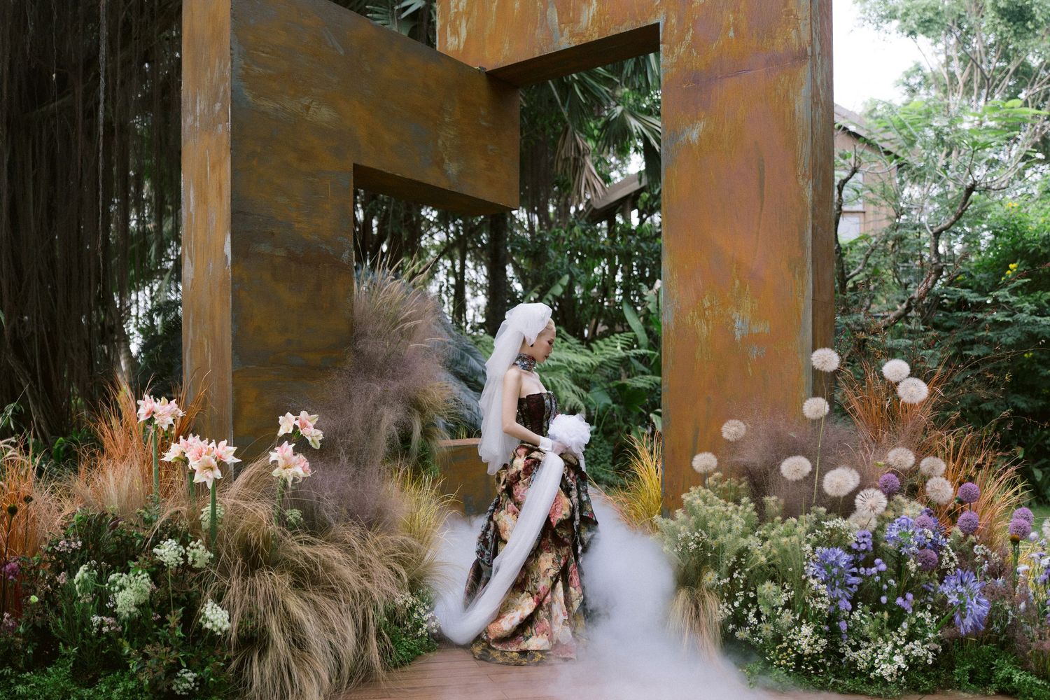 Ethereal garden scene with rustic metal archway, dried flowers, and misty atmosphere creating a dreamy outdoor setting.