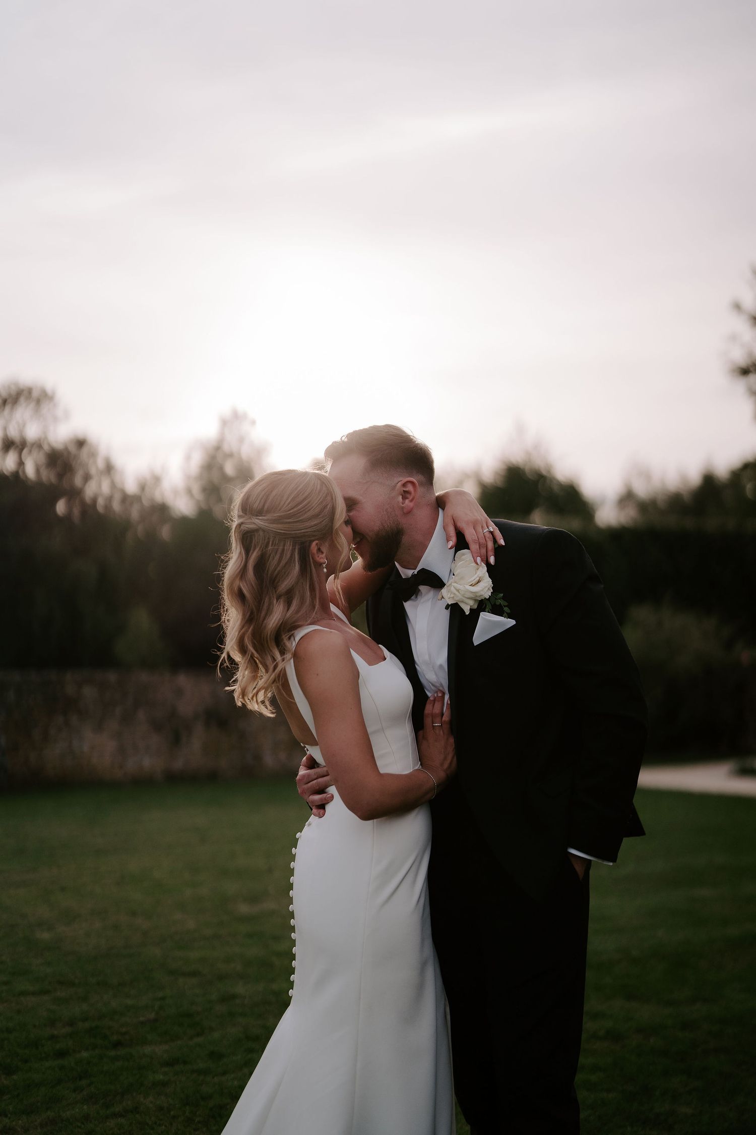 bride and groom kissing at sunset at ivy lodge wedding in cirencester