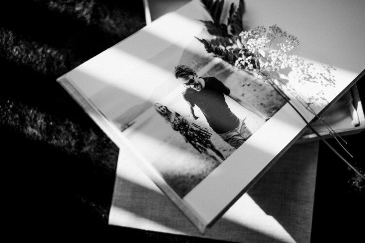 Black and white photograph of vintage wedding album photos spread across a surface.