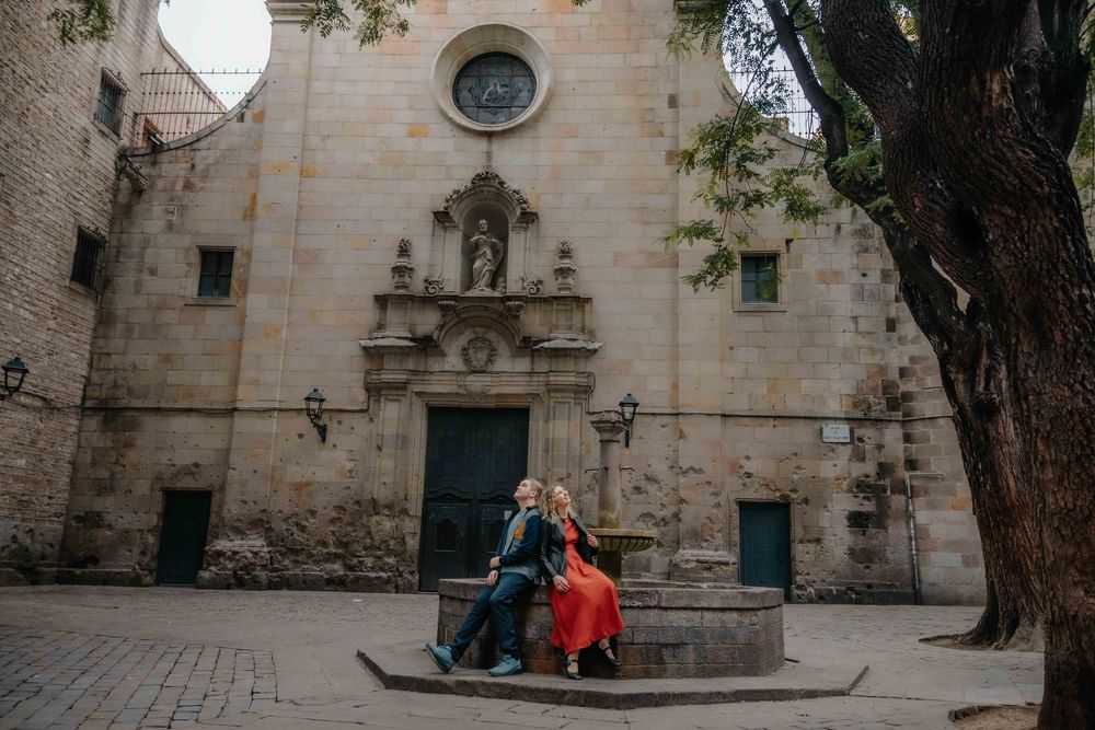 Couple sitting on the famous serpentine bench in Park Güell.