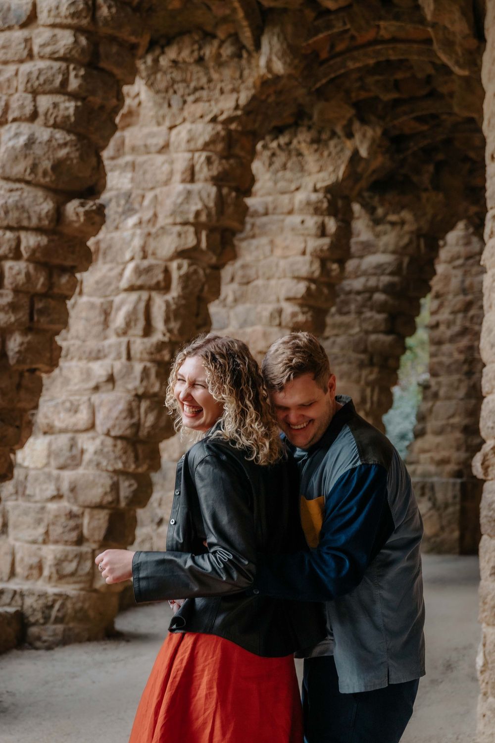 Couple walking through the stone viaducts of Gaudí’s park.