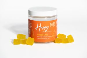 RnR Farms Happy CBD gummies in lemon drop flavor with yellow sugar-coated gummies scattered around jar on white background.