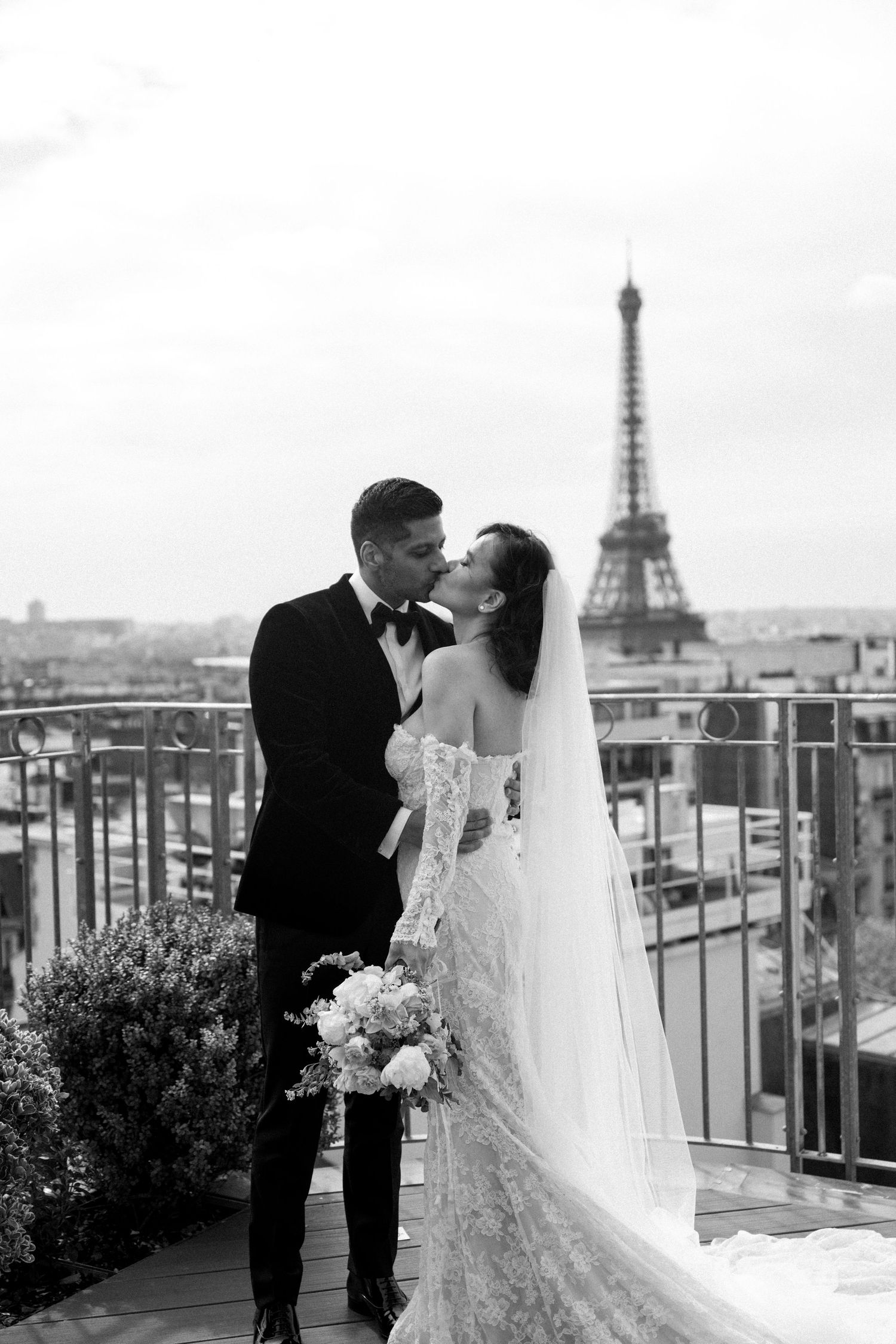 Best spots to elope in Paris. On a rooftop terrace with the Eiffel Tower visible in the Paris skyline.