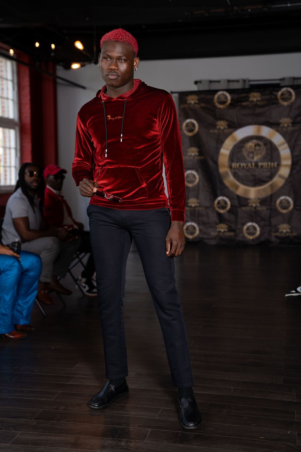 A dance performance on a dark wooden floor with dramatic lighting and circular decorative elements on the back wall.