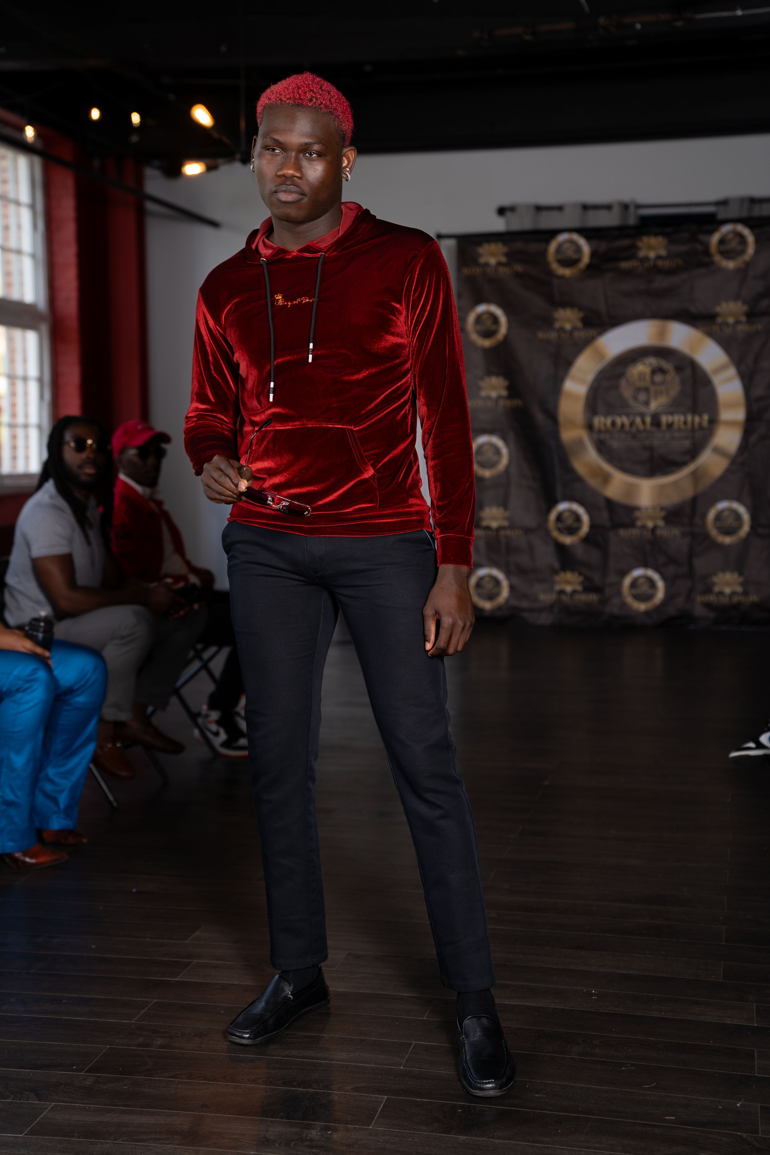 A dance performance on a dark wooden floor with dramatic lighting and circular decorative elements on the back wall.