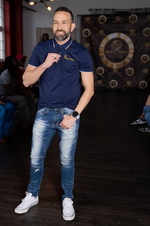 A series of casual poses showing someone in jeans and a navy polo shirt against a dark studio backdrop.