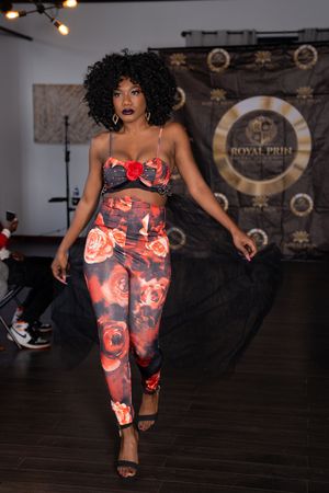 A dance performance featuring red and orange patterned activewear on a dark wooden stage.
