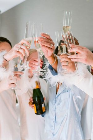 Wedding party toasts with champagne glasses in a celebratory moment.