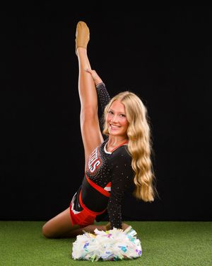 Cheerleader performs dynamic leg kicks in sequence on artificial turf wearing black and red uniform.