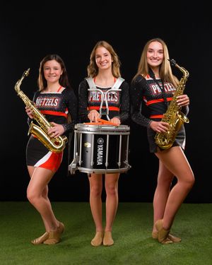 Band members pose with musical instruments including saxophones and drums against a black and green background.