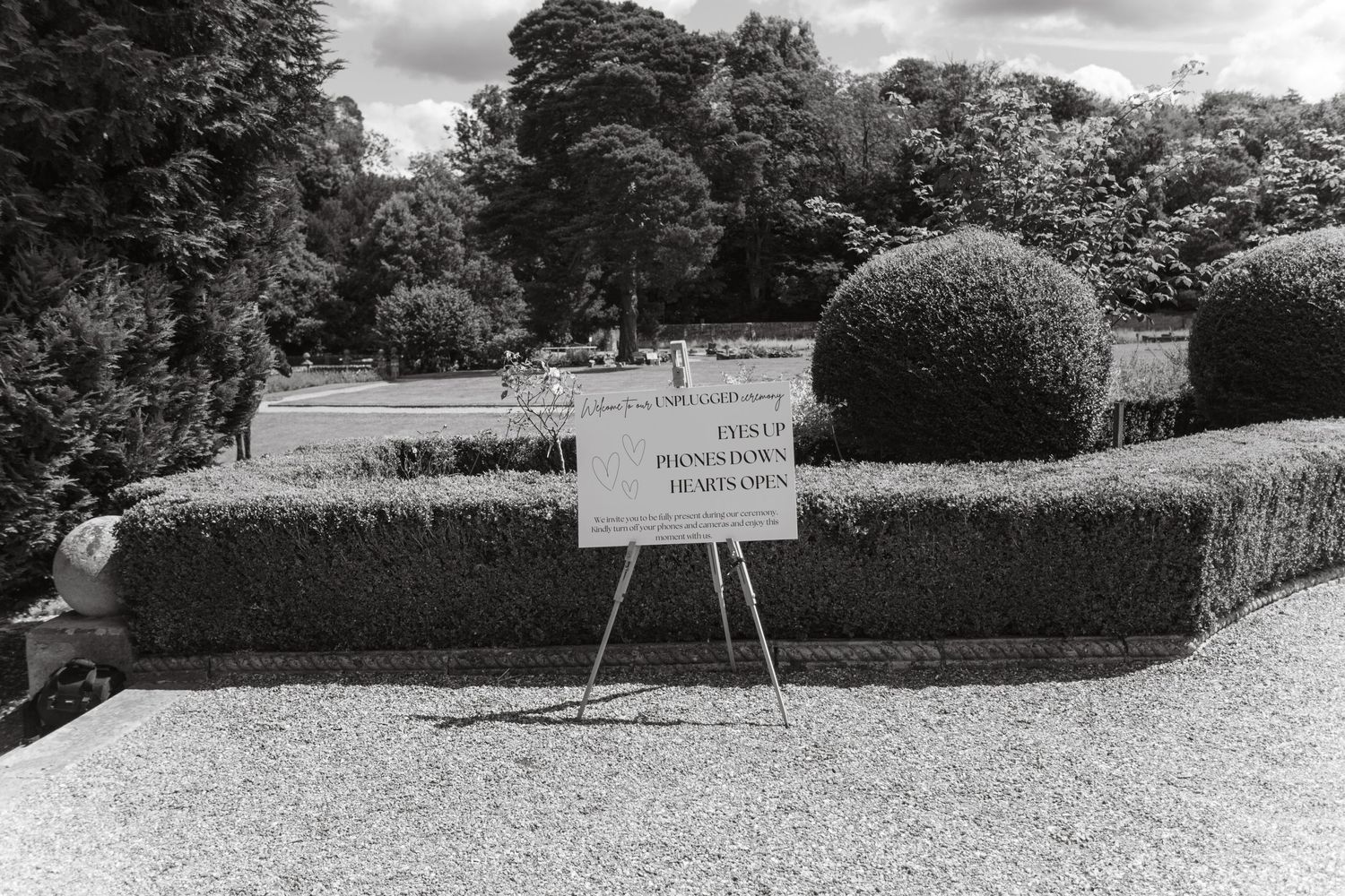 Scenic view of a grand estate's landscaped grounds with cloudy sky.