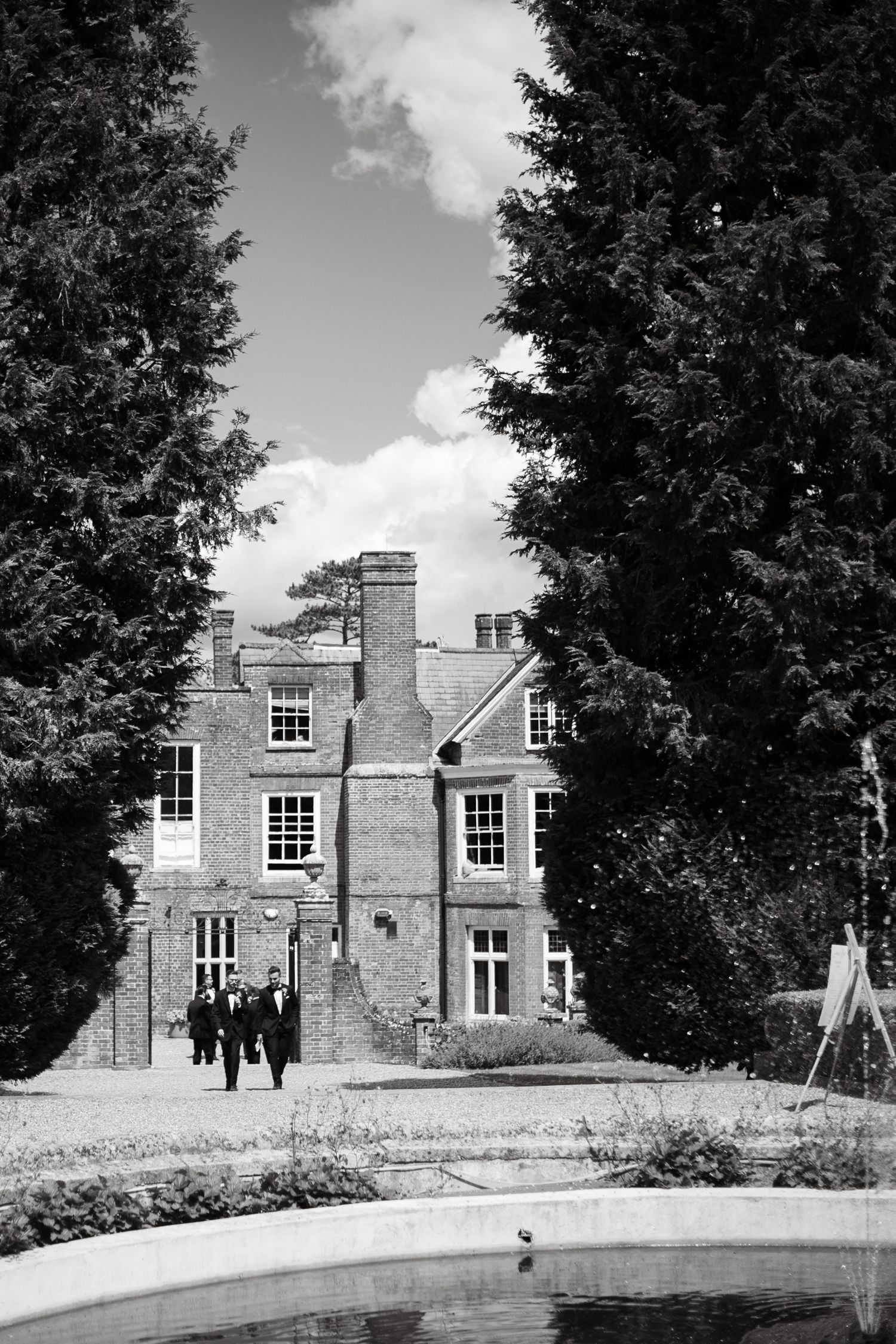 Elegant stone manor house with traditional windows and architecture against a blue sky.