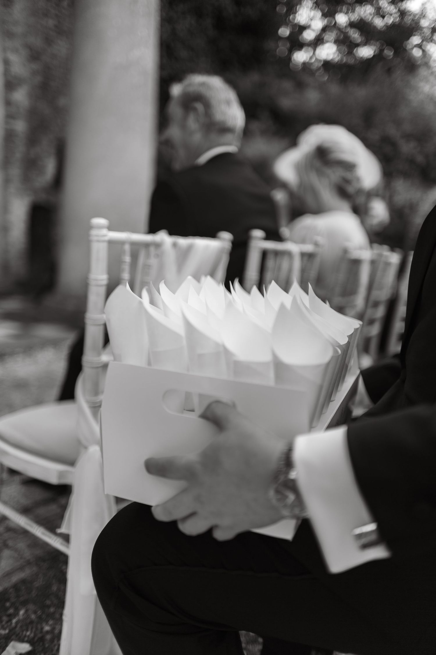 Black and white image of wedding favors or gift boxes being carried.