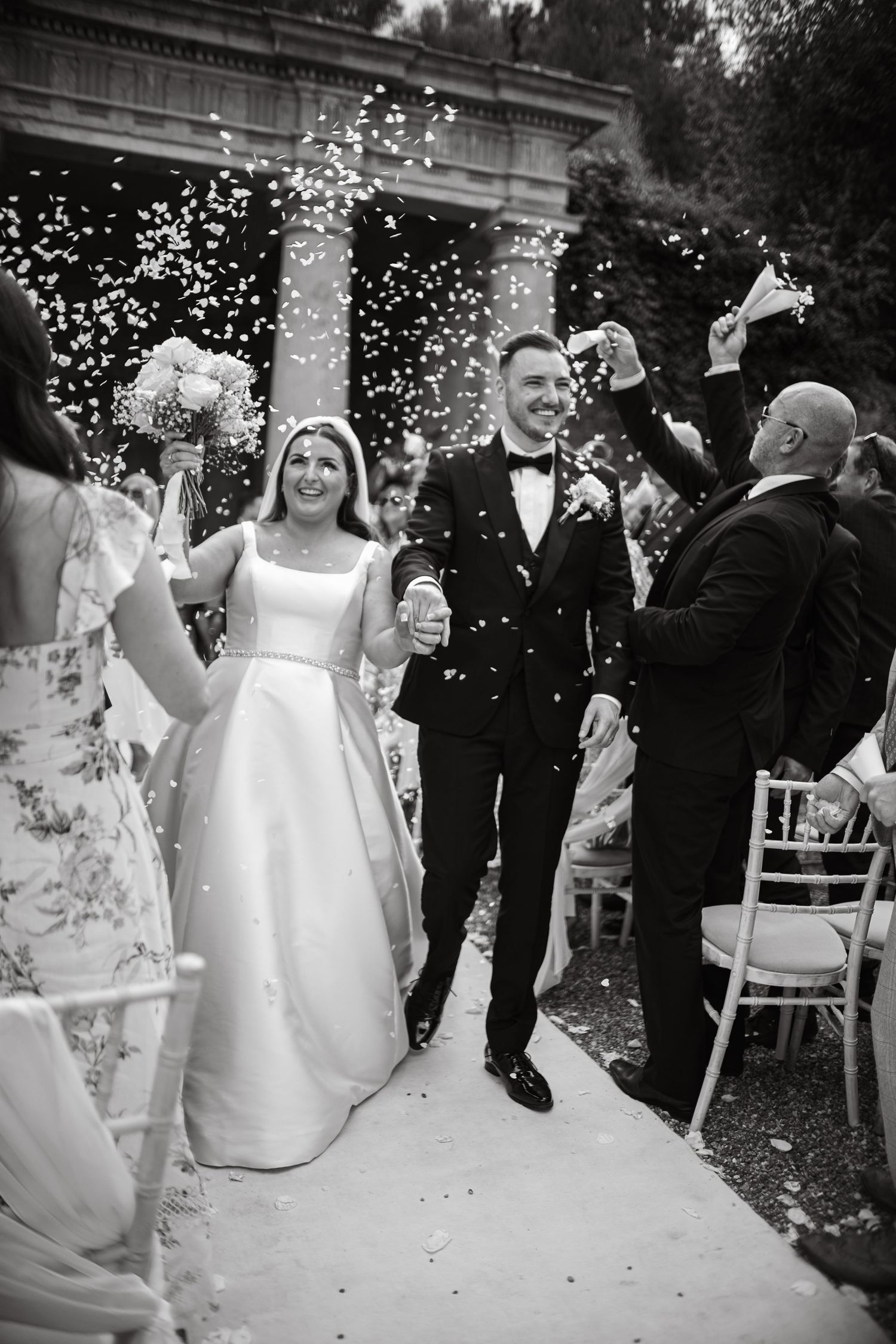Celebratory moment as newlyweds exit ceremony under shower of confetti.