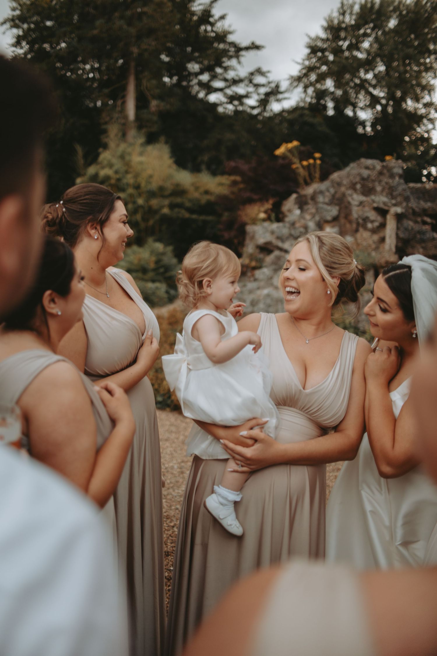 A joyful group in matching dresses sharing a candid moment outdoors.
