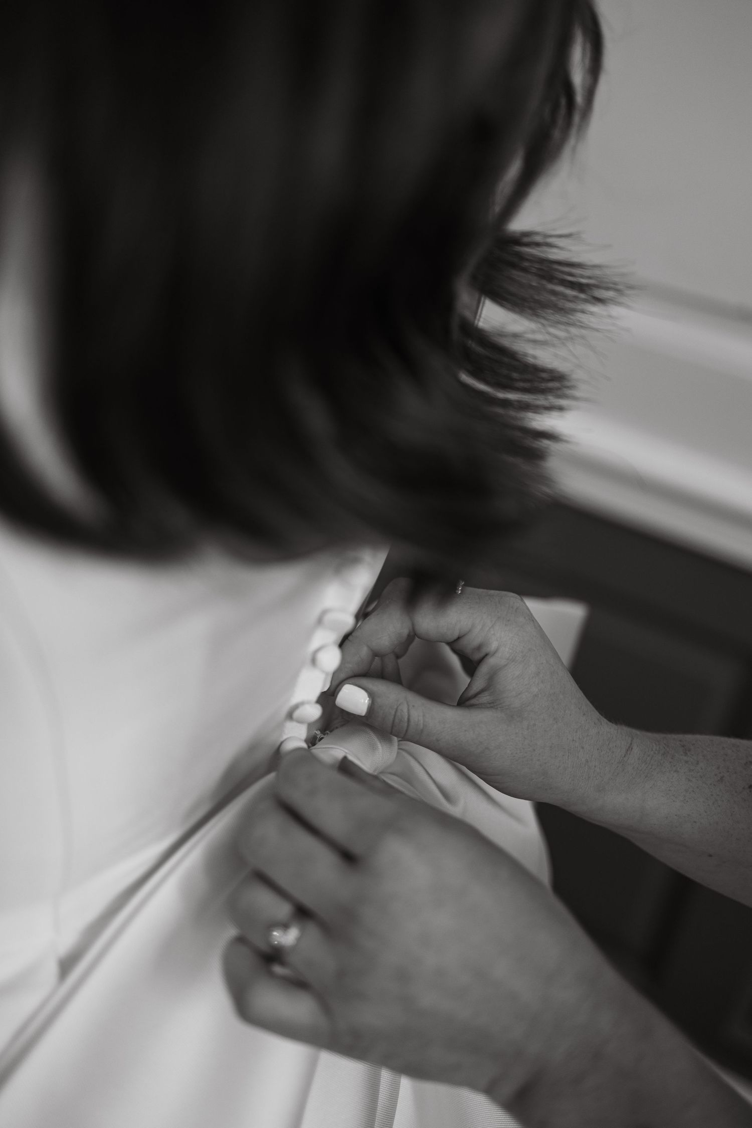 Close-up sequence showing hands placing an engagement ring in black and white.
