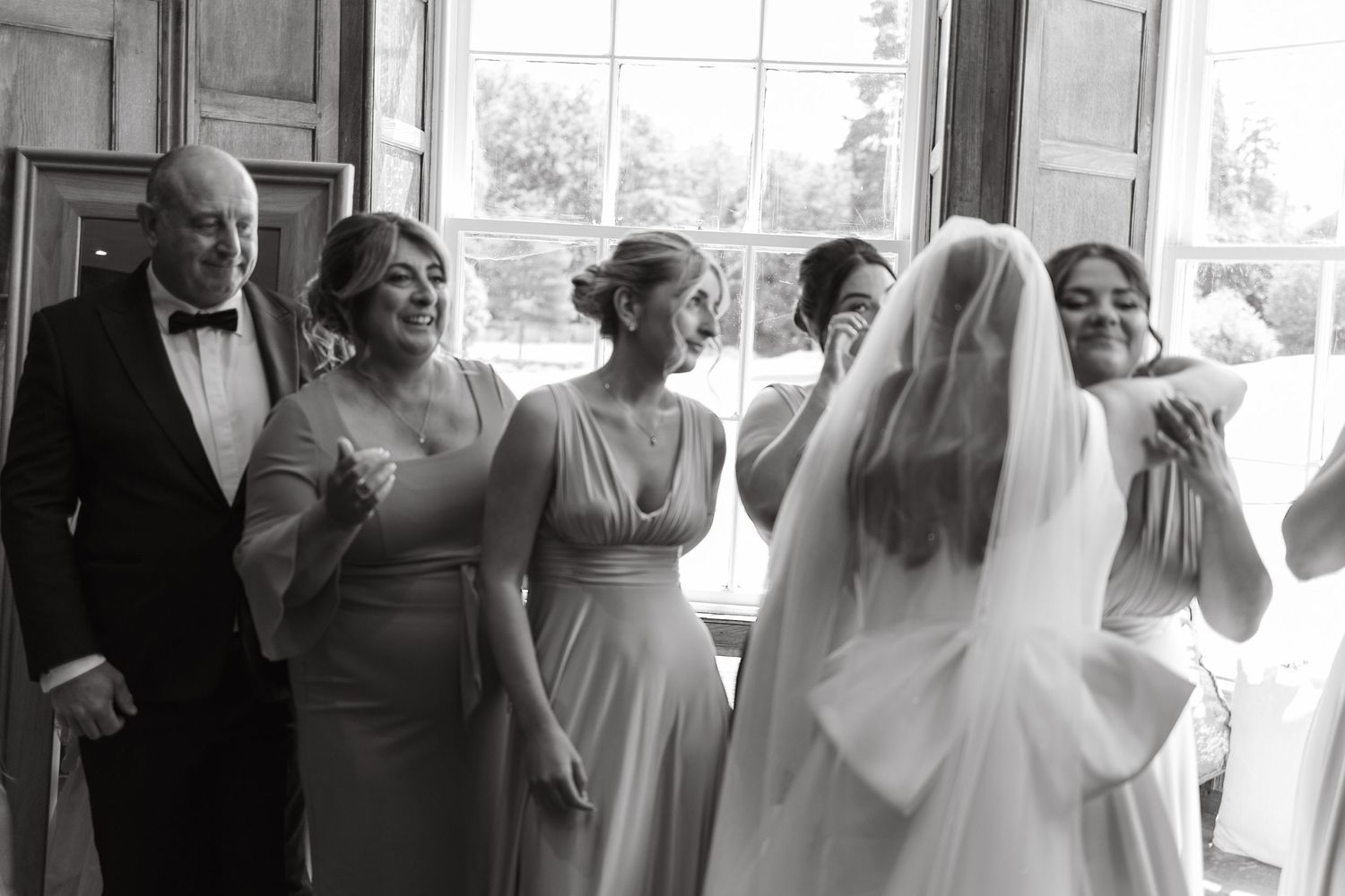 Wedding party members gather in bright indoor venue during celebration.