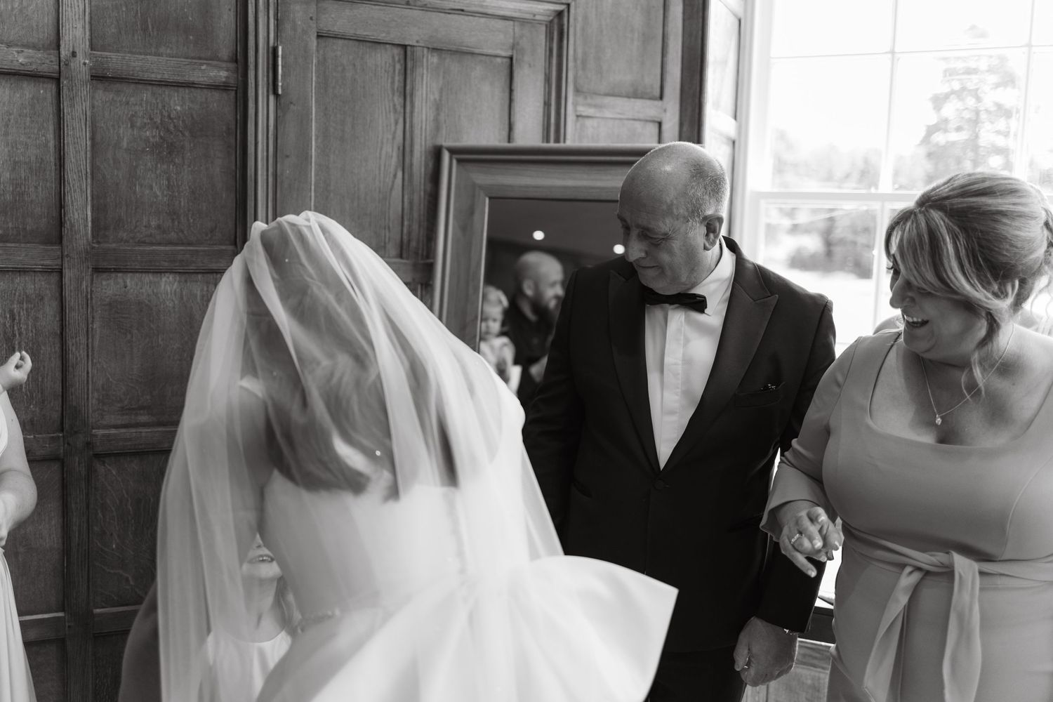 Wedding party members sharing intimate moments before the ceremony in a classic interior.