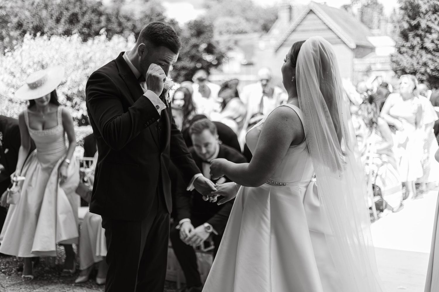 Black and white wedding celebration photo capturing joyful moments between guests.
