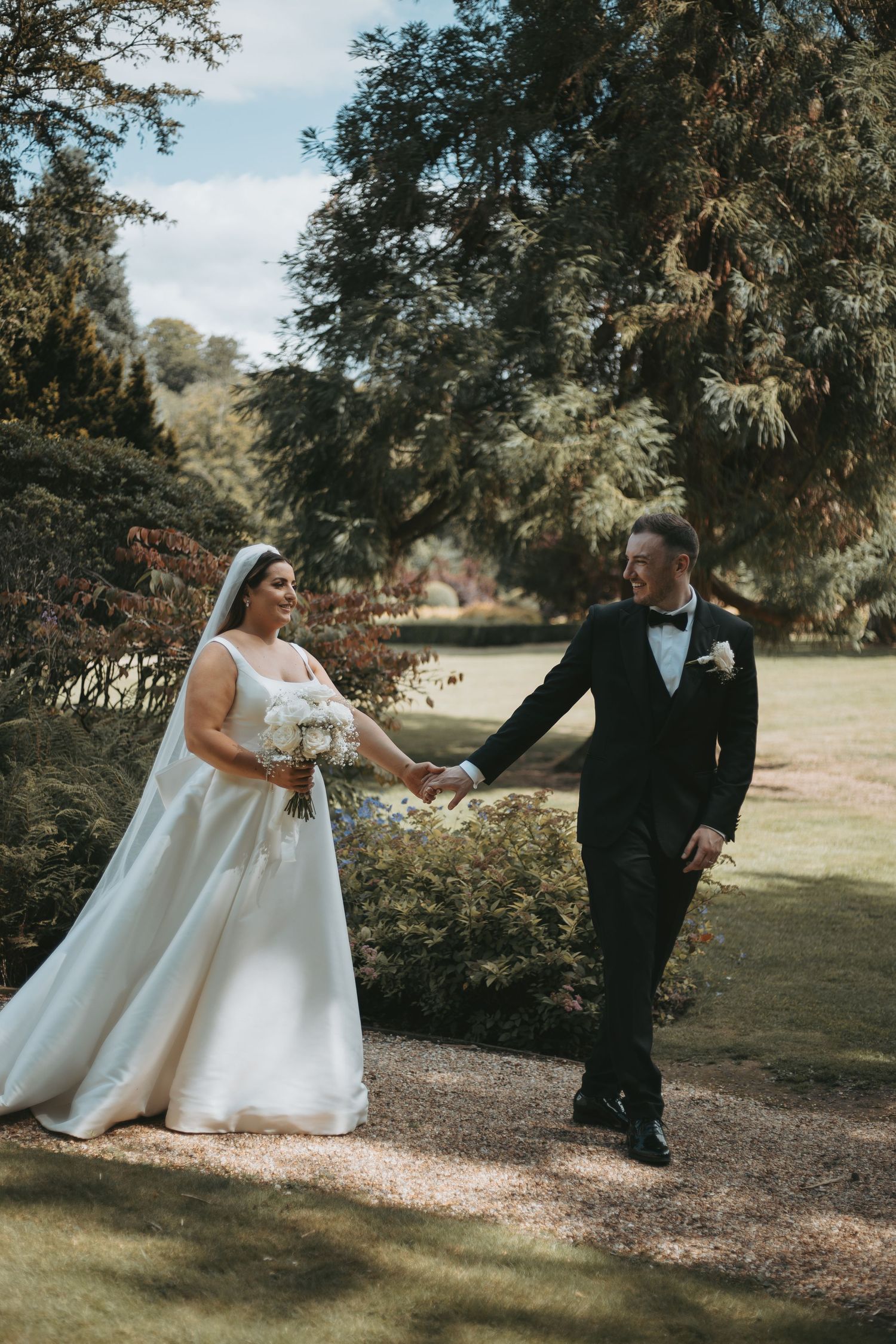 Candid wedding photos showing playful moments between newlyweds in an outdoor garden setting.