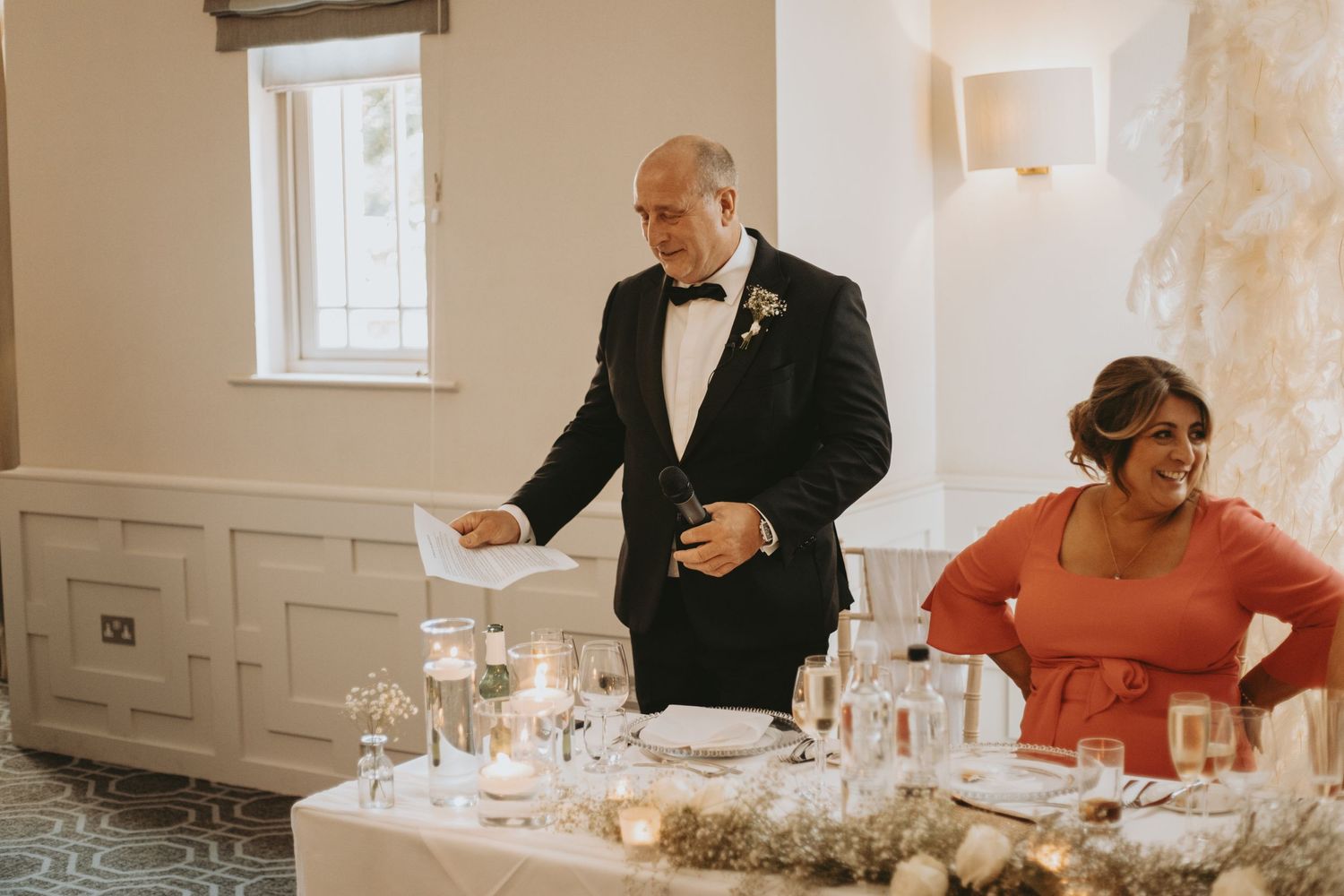 A formal dining setup with candles and table settings at an elegant indoor venue.
