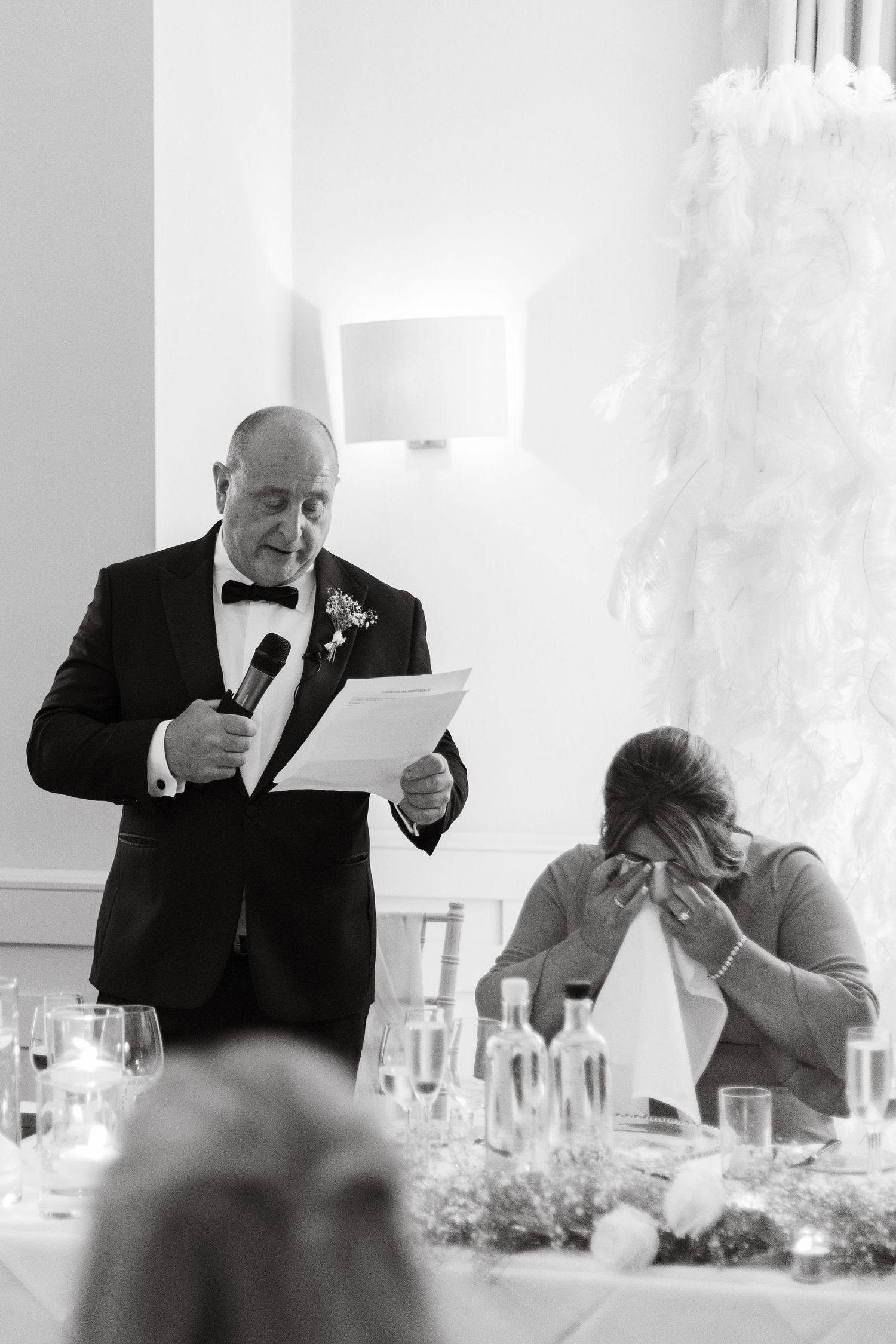 Speaker delivers emotional wedding toast at formal reception dinner.