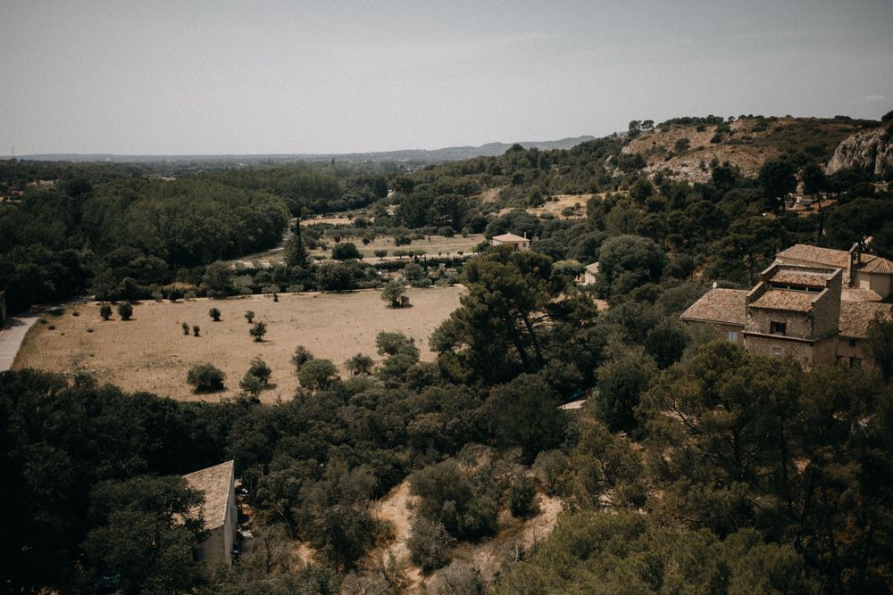 Aerial view of Mediterranean countryside with scattered houses and olive groves on hillside.