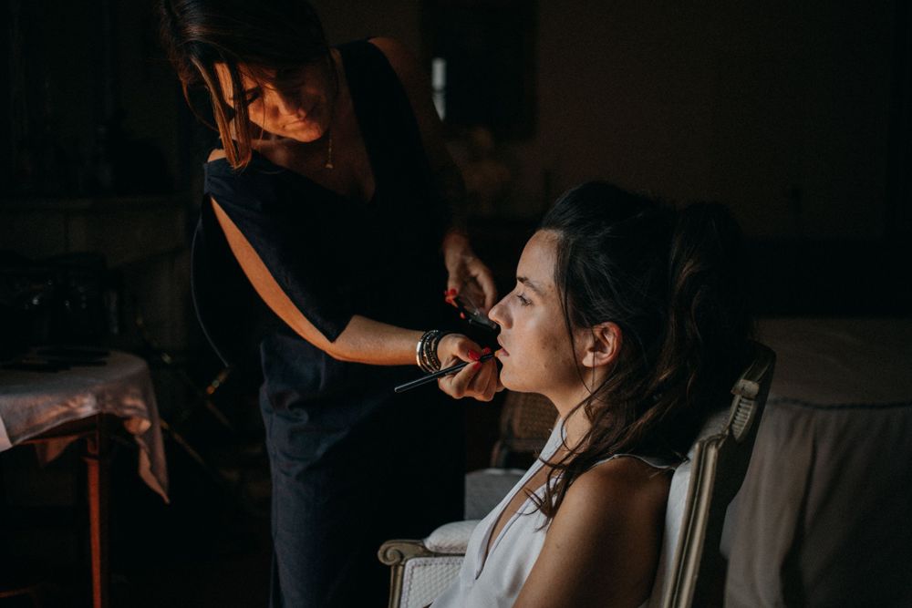 Getting ready scene in dramatic lighting with makeup application.