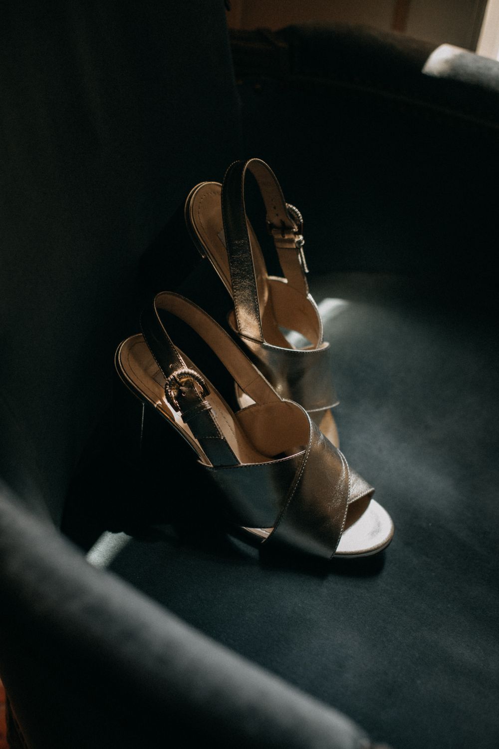 Elegant black and tan women's heels with strappy design photographed in dramatic low light.