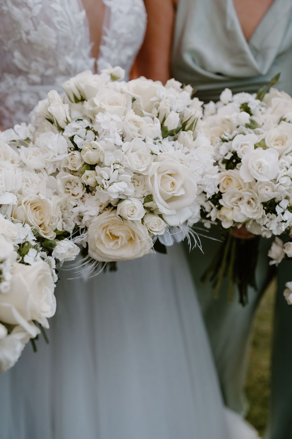 Close-up view of white roses and delicate floral arrangements adorning an elegant wedding setting with soft lighting.