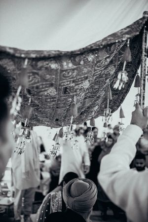 A sequence of black and white photos showing people gathered under writing on a dark ceiling.