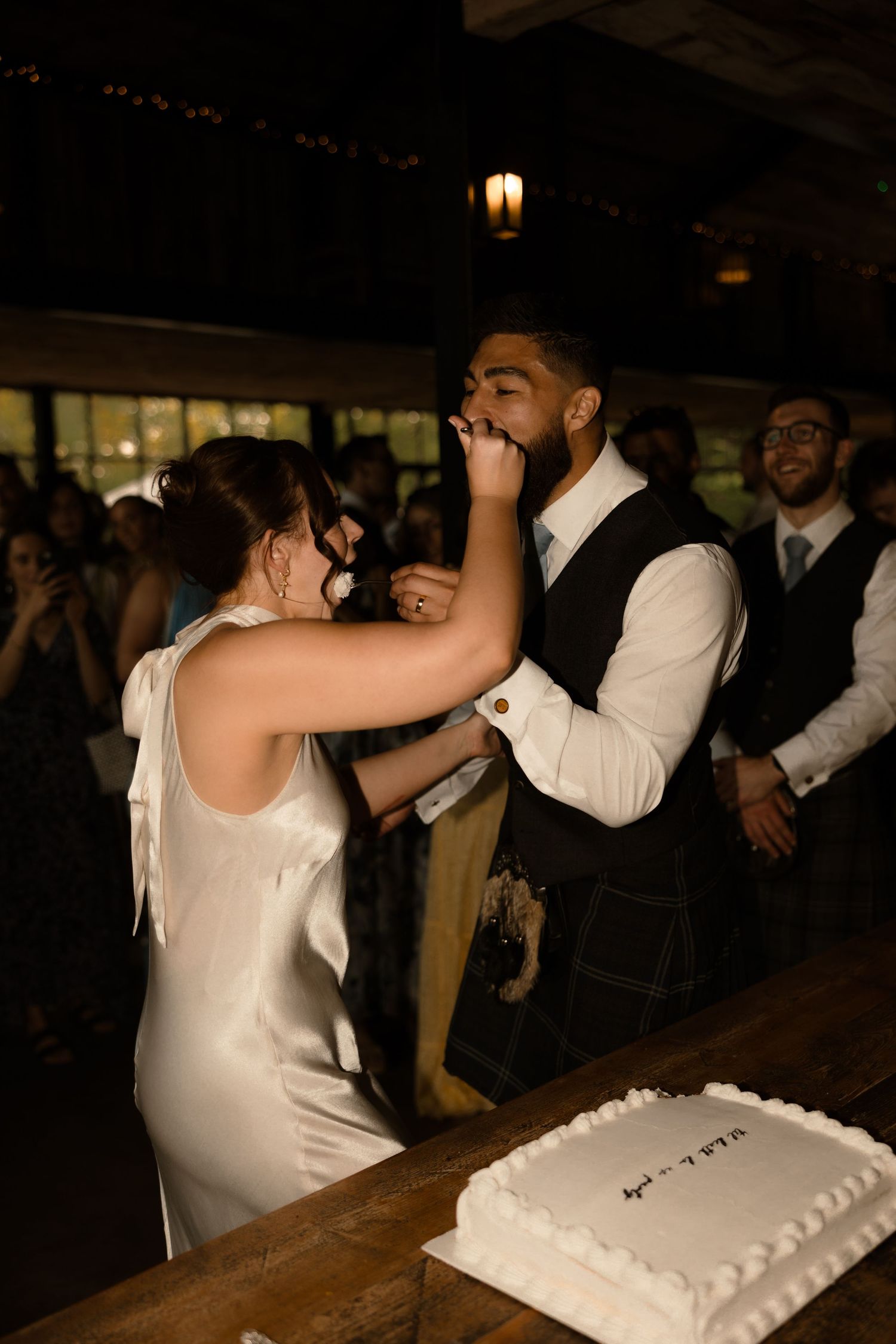 A creative series of photos showing couples dancing at a dimly lit wedding reception next to cake displays.