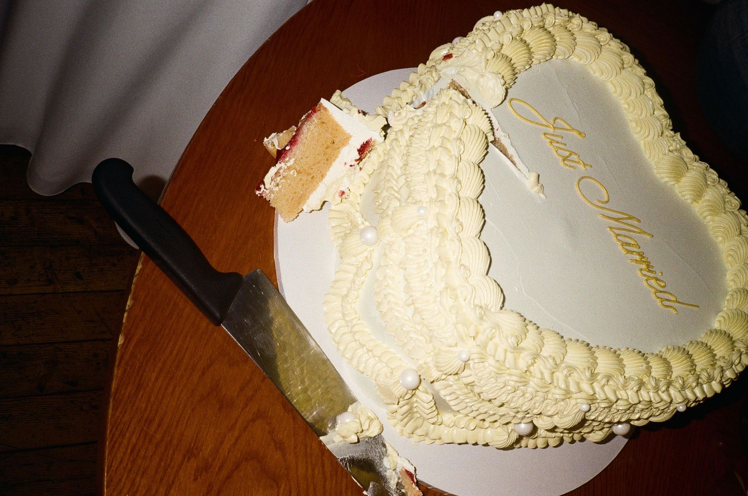 A series of snapshots showing a white frosted cake being cut into slices with a knife on a wooden surface.