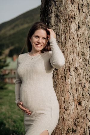 Těhotenské focení v přírodě poblíž Vrchlabí – budoucí maminka v dlouhých šatech a jemném světle Krkonoš