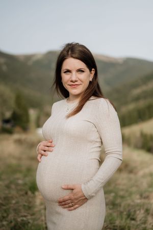 Těhotenské focení v přírodě poblíž Vrchlabí – budoucí maminka v dlouhých šatech a jemném světle Krkonoš