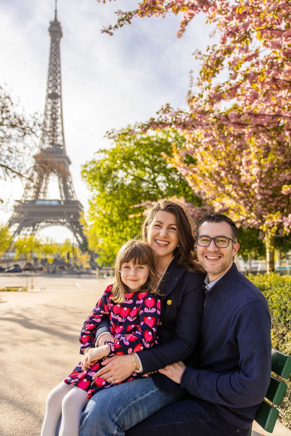 Autumn scene near the Eiffel Tower in Paris with colorful fall foliage and a park bench under sunny skies.