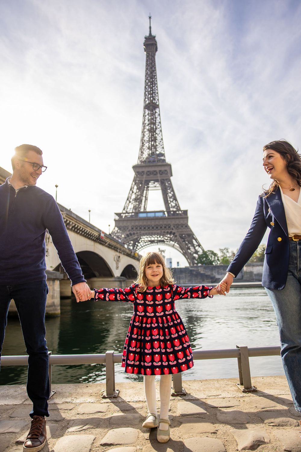 A scenic family moment along the Seine River with the iconic Eiffel Tower rising majestically in the background.