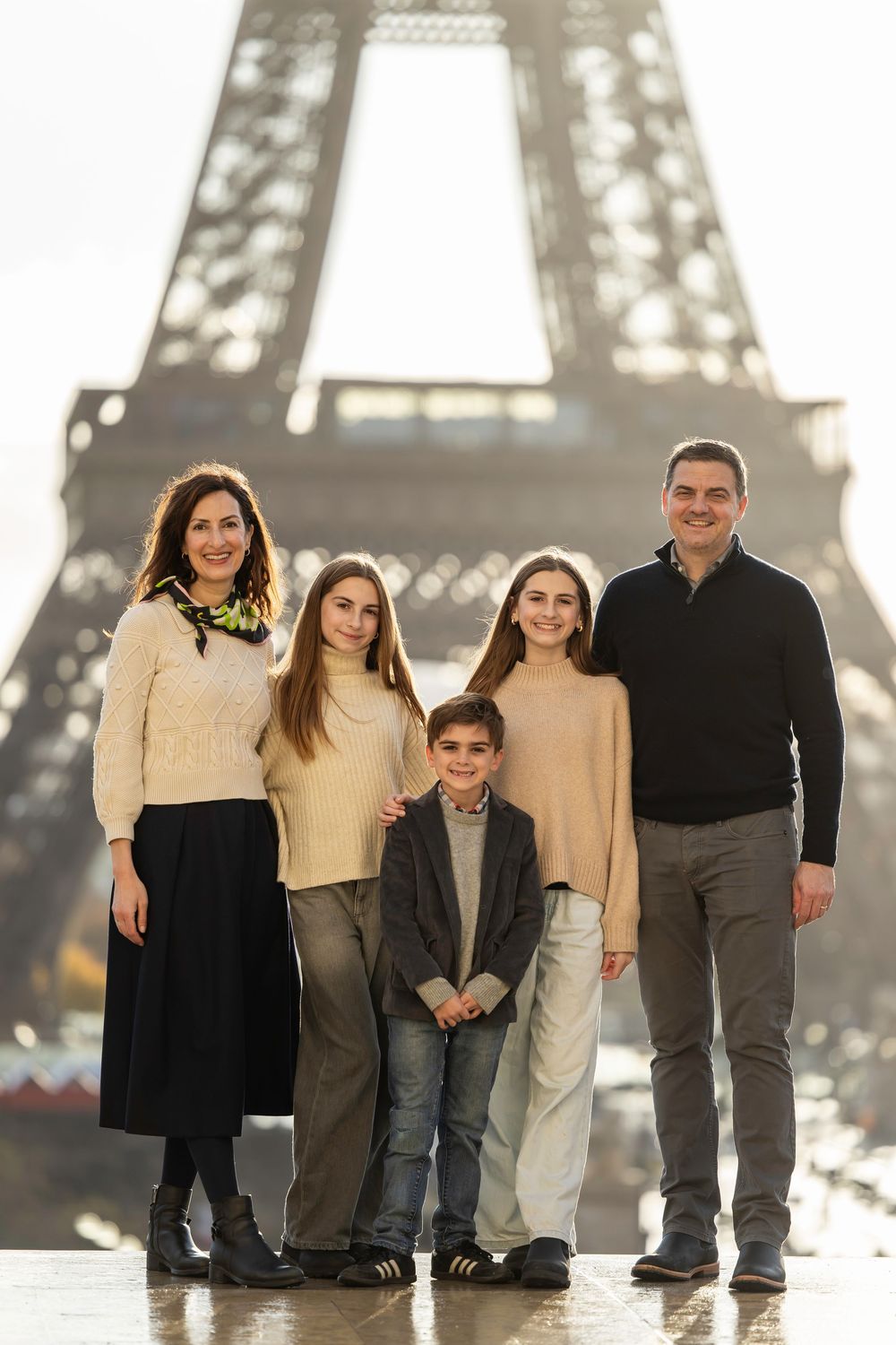 Group of people posing in front of the iconic Eiffel Tower in Paris.