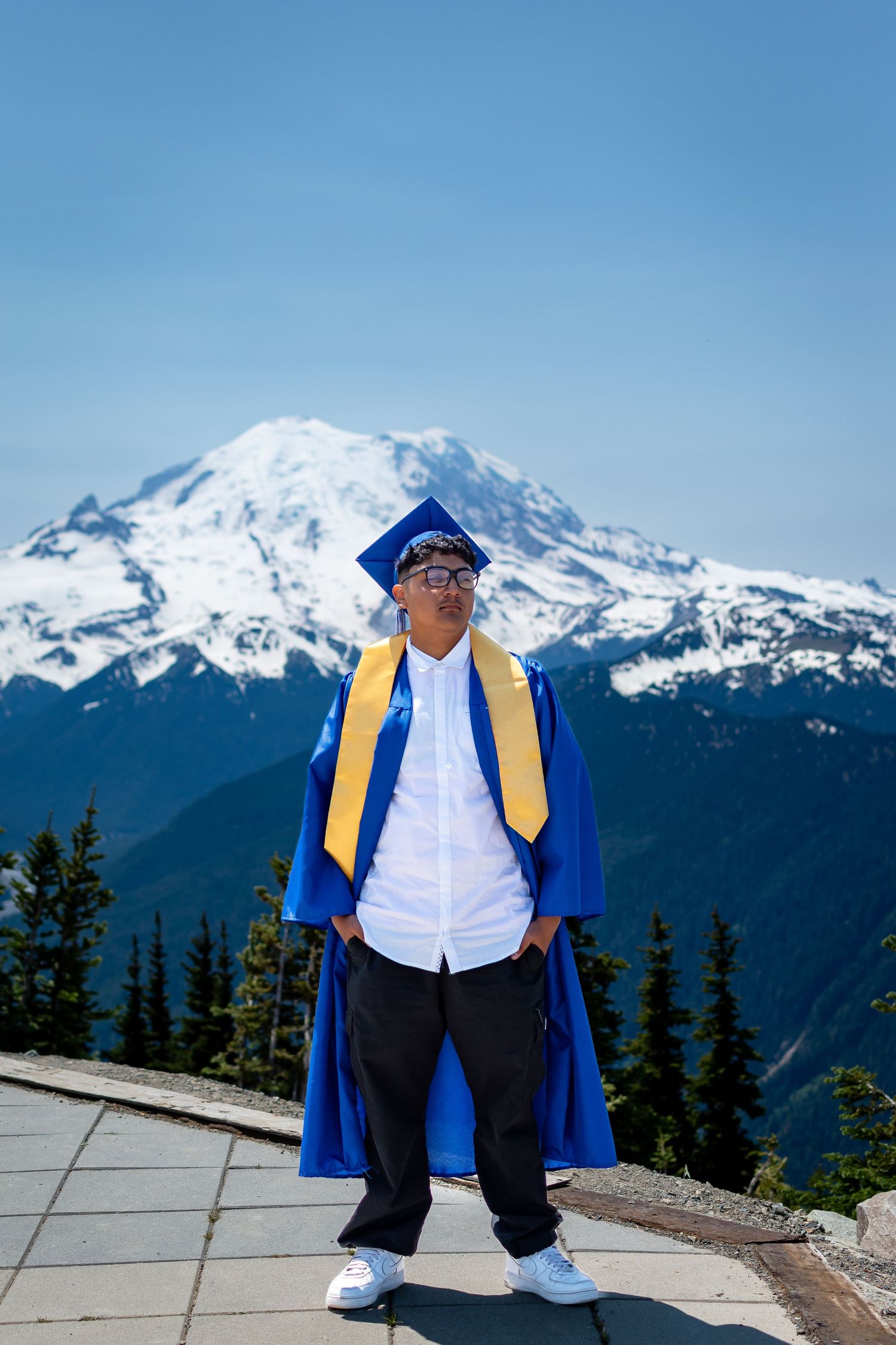 Class of 2025 graduate posing at the Crystal Mountain summit with panoramic views of Mount Rainier and the Cascade Range.