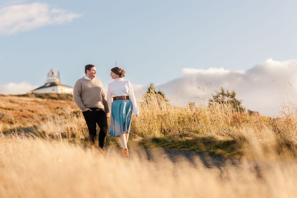 Couple walking together through golden wheat fields at sunset along a scenic rural path.