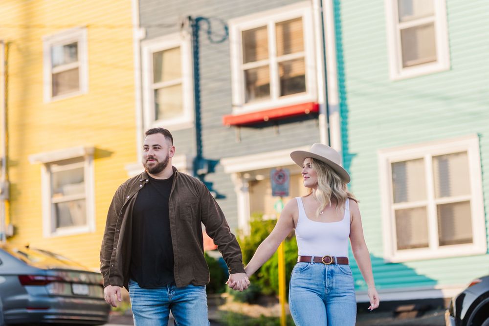 Group walking past colorful row houses, or JellyBean Row, of Downtown St.John's on a charming residential street.