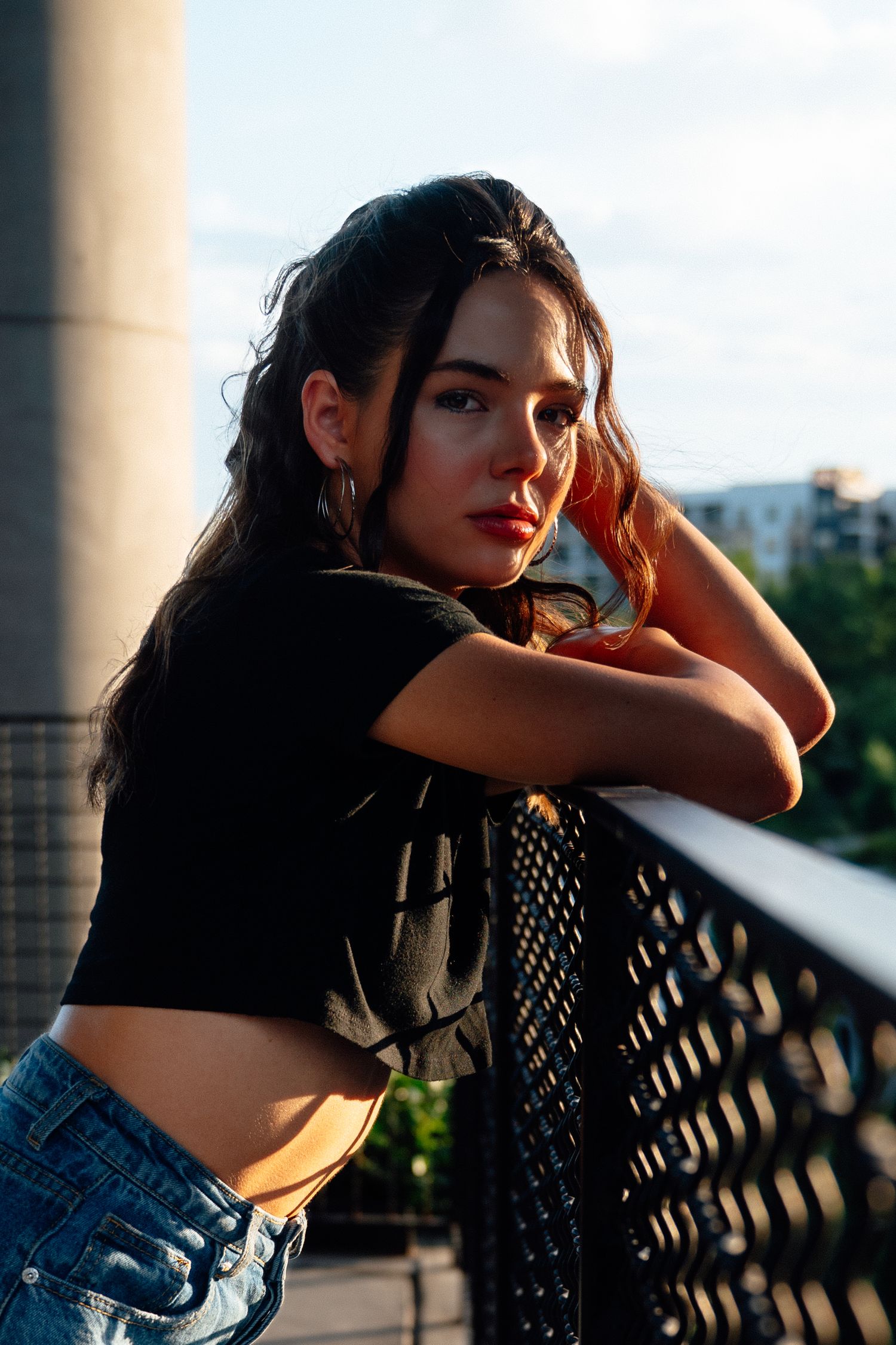 Artistic portrait sequence against metal railing during golden hour.