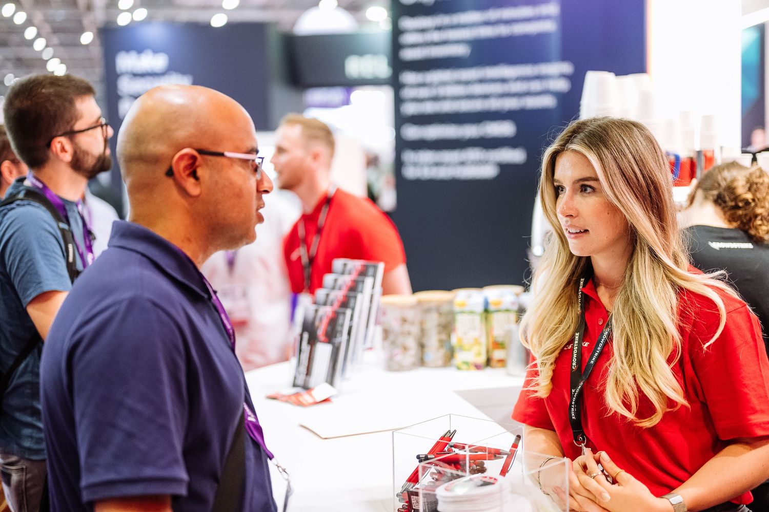 Attendees networking and engaging in discussions at a technology conference exhibition.