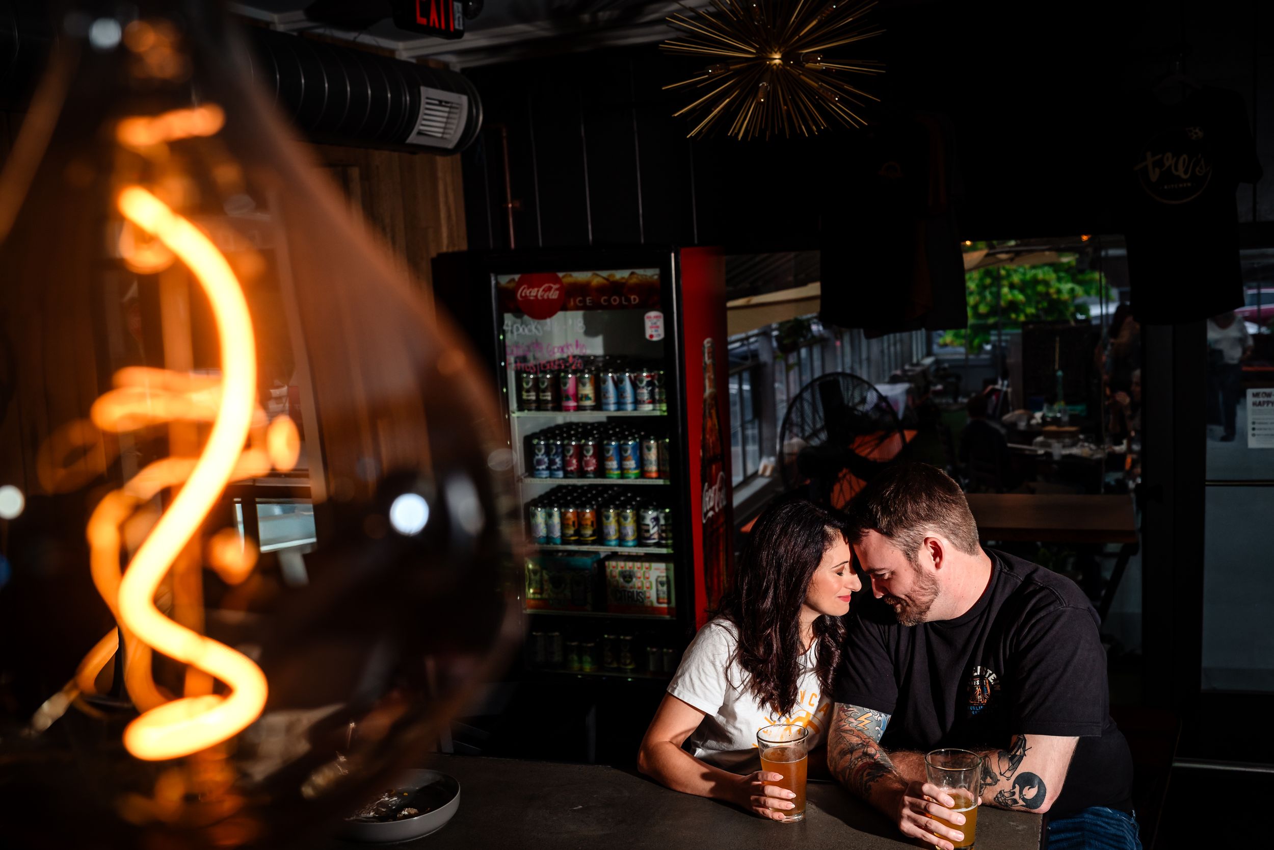 Dark atmospheric bar interior with hanging lights creating a cozy ambiance.