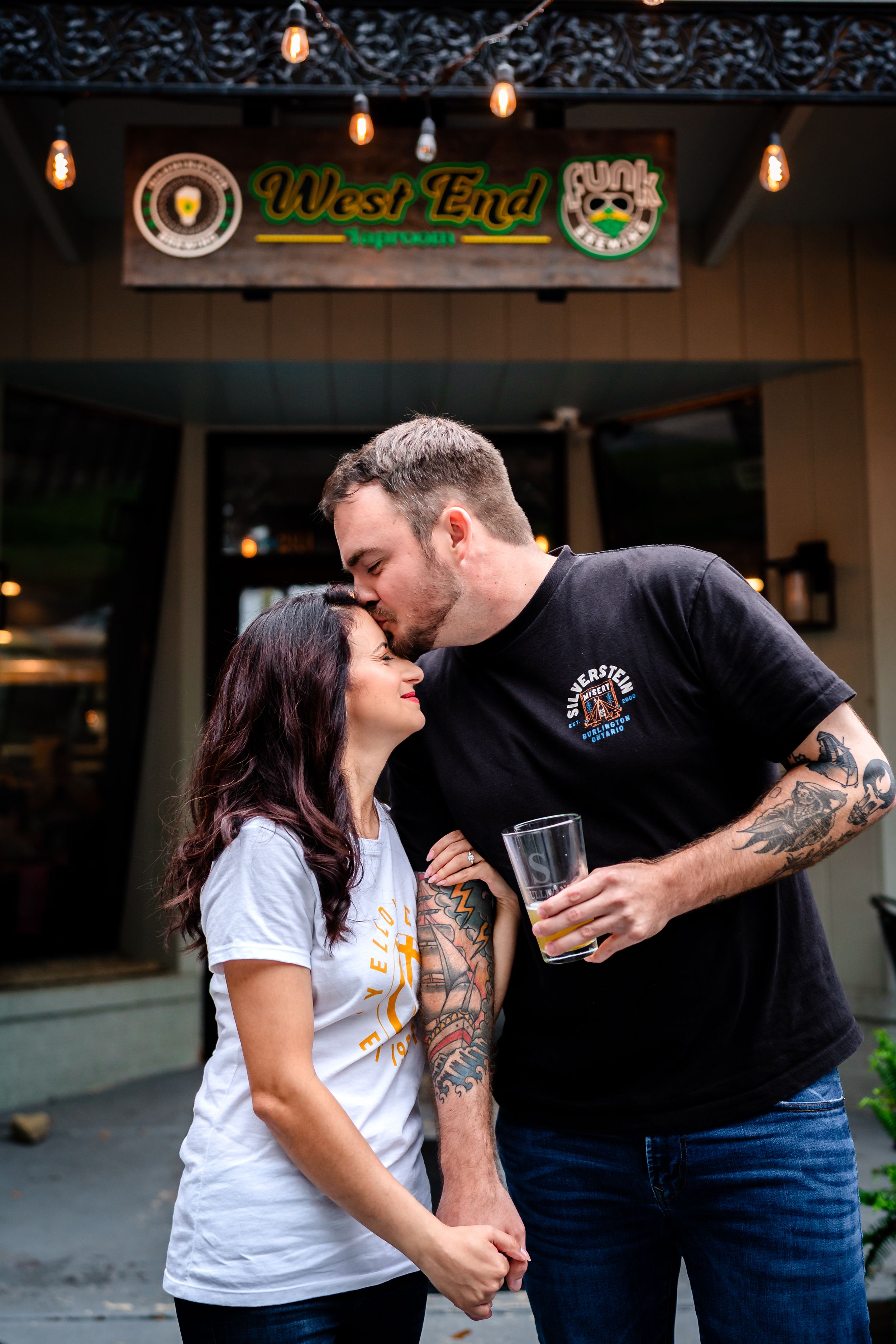Couple laughing and enjoying each other's company outside West End bar.
