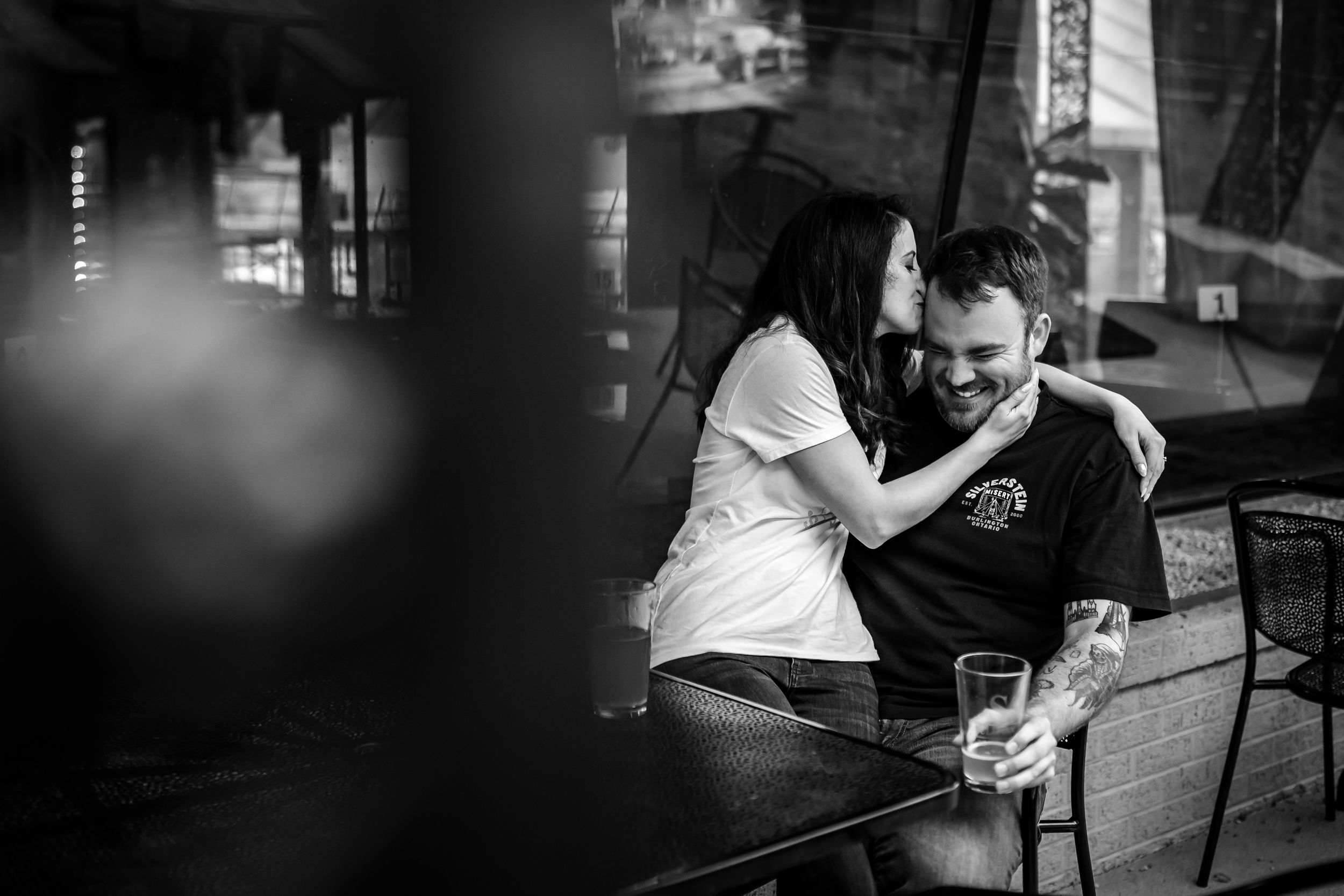 Black and white photo of couple playing board games at a dimly lit bar.